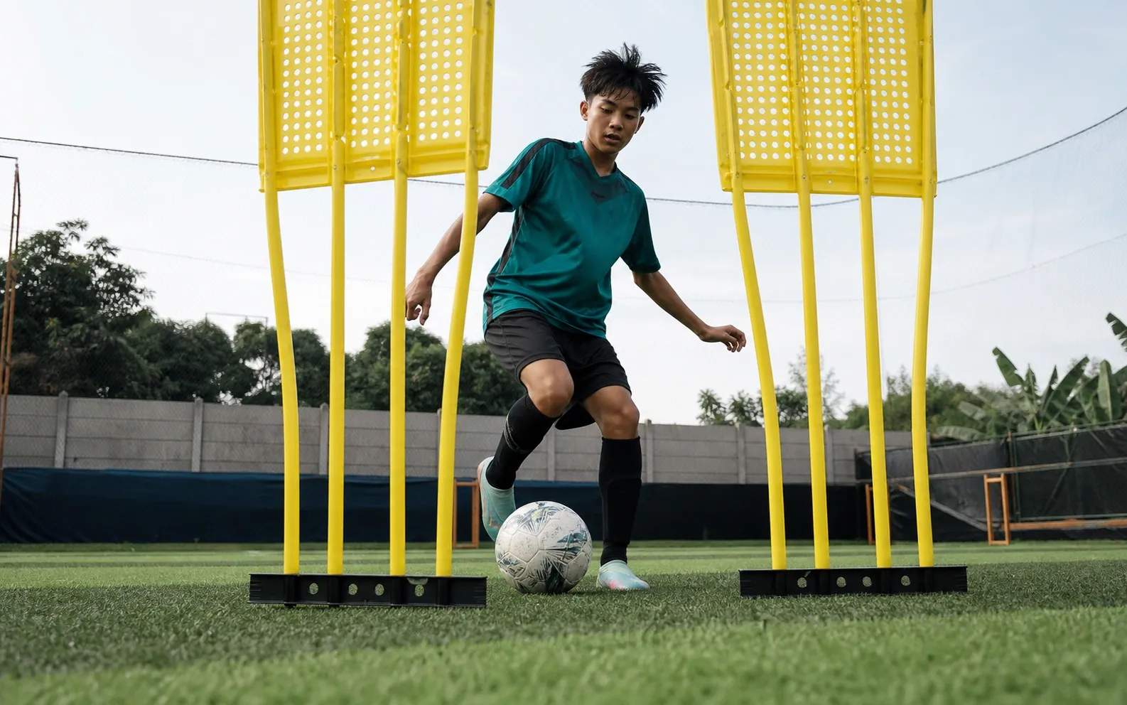 Bola melintas aman di antara dua rintangan latihan dalam latihan kolong