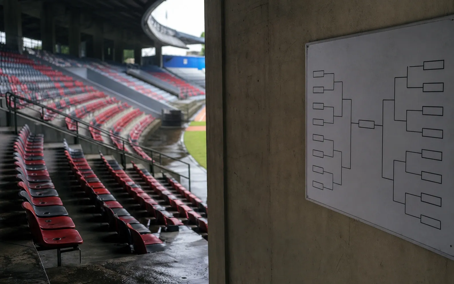 Lorong stadion dan deretan kursi kosong menjelang pertandingan rivalitas